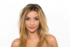 Shooting Photo Priscilla en studio, réalisé par le photographe à Nice Yan Forhan, mettant en valeur son regard expressif sur fond blanc.