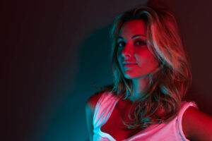 Shooting Photo Priscilla sous une lumière contrastée rouge et bleue, capturé par Yan Forhan, photographe à Nice.
