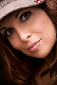 Portrait rapproché d’Hélène Ségara, capturé par Yan Forhan, mettant en avant son regard expressif et son expression mystérieuse sous une casquette beige.