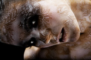 Portrait artistique de Lorie avec un maquillage en dentelle, réalisé par Yan Forhan, photographe officiel de Lorie Pester, et maquillé par Damien Dufresne. Image issue de son livre photo exclusif.